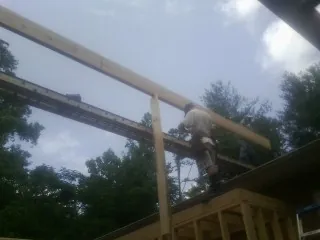 Carpenter setting a ridge beam over a new addition frame — Ice Dam Removal by Roofing Brothers in Berkey