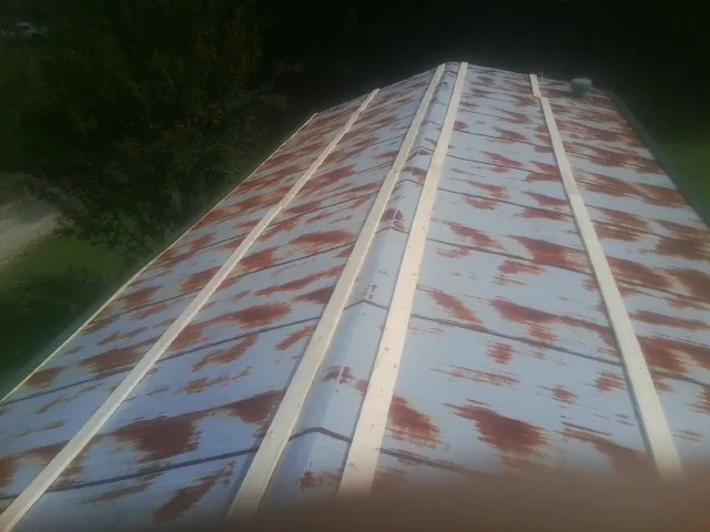 Rusted metal roof panels with new wood purlins before replacement — Storm Damage Roof Repair in Berkey by Roofing Brothers